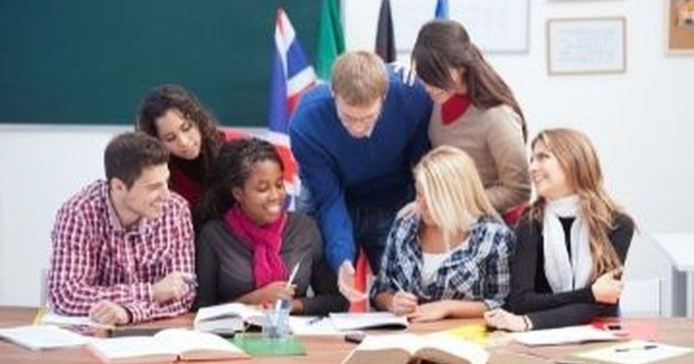 Group of students gathered around a table, a typical school photo subject