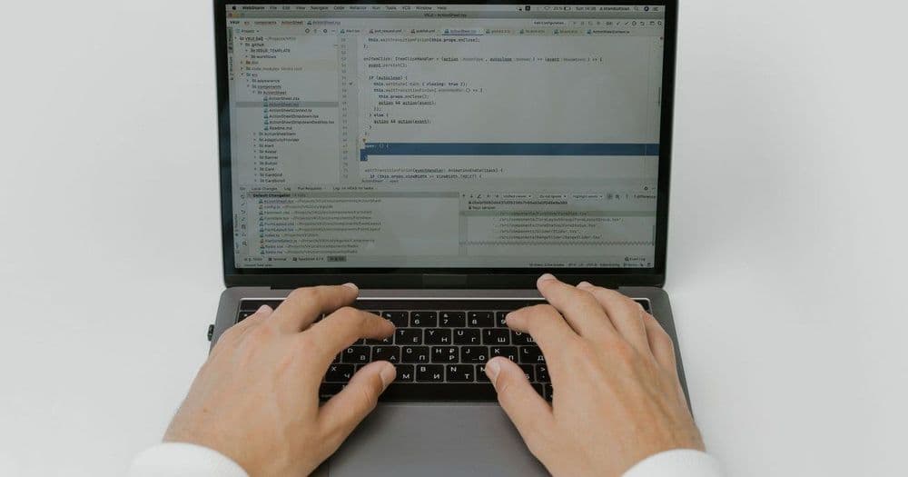 Hands typing on a laptop at a clean desk, representing corporate print ordering